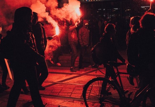 Rauch, Protest. In rotem rauch getauchte Demonstranten und Pyros im Hintergrund. Journal EXIT-Deutschland.